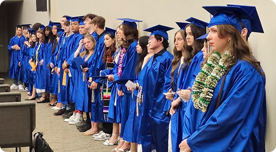 graduates in caps and gowns standing in a line.