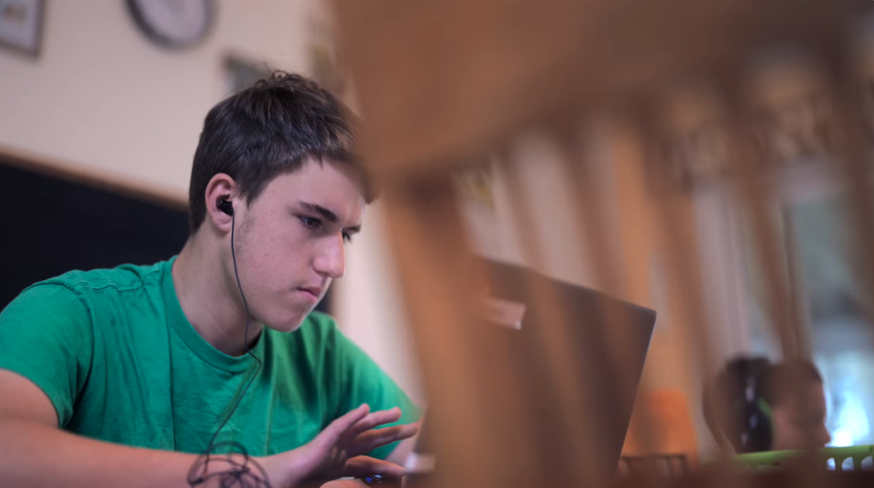 student with headphones working on computer