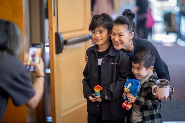 teacher smiling with two young kids.